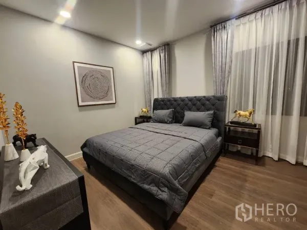 Detached House for rent or sale - Cozy bedroom with quilted gray bed, wood flooring and full-height curtains