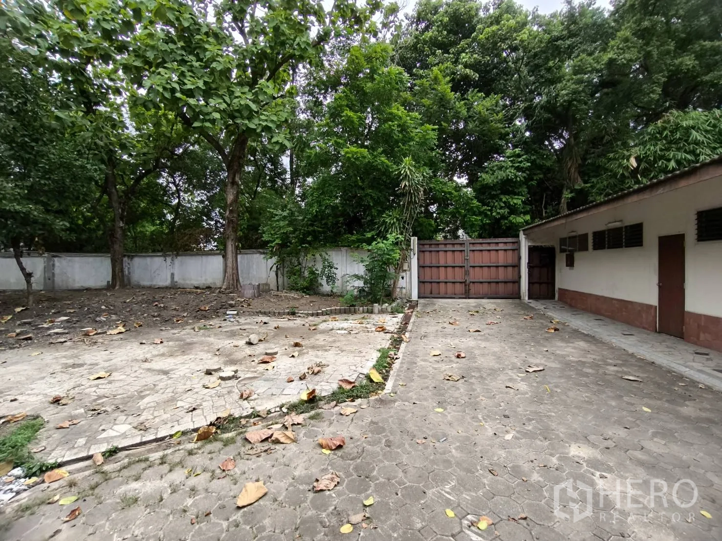 พื้นที่ขายปลีก ให้เช่าในWang Thonglang, Bangkok - ประตูทางเข้าแบบมีกำแพงรอบลาน ทางรถปูพื้น ใต้ร่มไม้ใหญ่