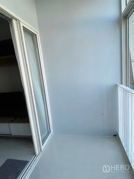 Condominium for rent in Phra Khanong, Bangkok - Bright condo balcony with white railing and sliding glass door in Phra Khanong.