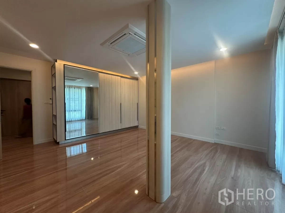 Townhouse for rent in Watthana, Bangkok - Alternate view of master bedroom showing large built-in wardrobe and windows.