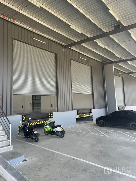 工厂 出租在Bang Pakong, Chachoengsao - 带调节月台的遮雨装卸区，卷帘门、停车位与坡道。