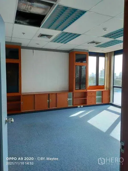 办公空间 出租在Watthana, Bangkok - 转角独立办公室，内置木柜、大窗户与蓝色地毯，可赏城市景观。