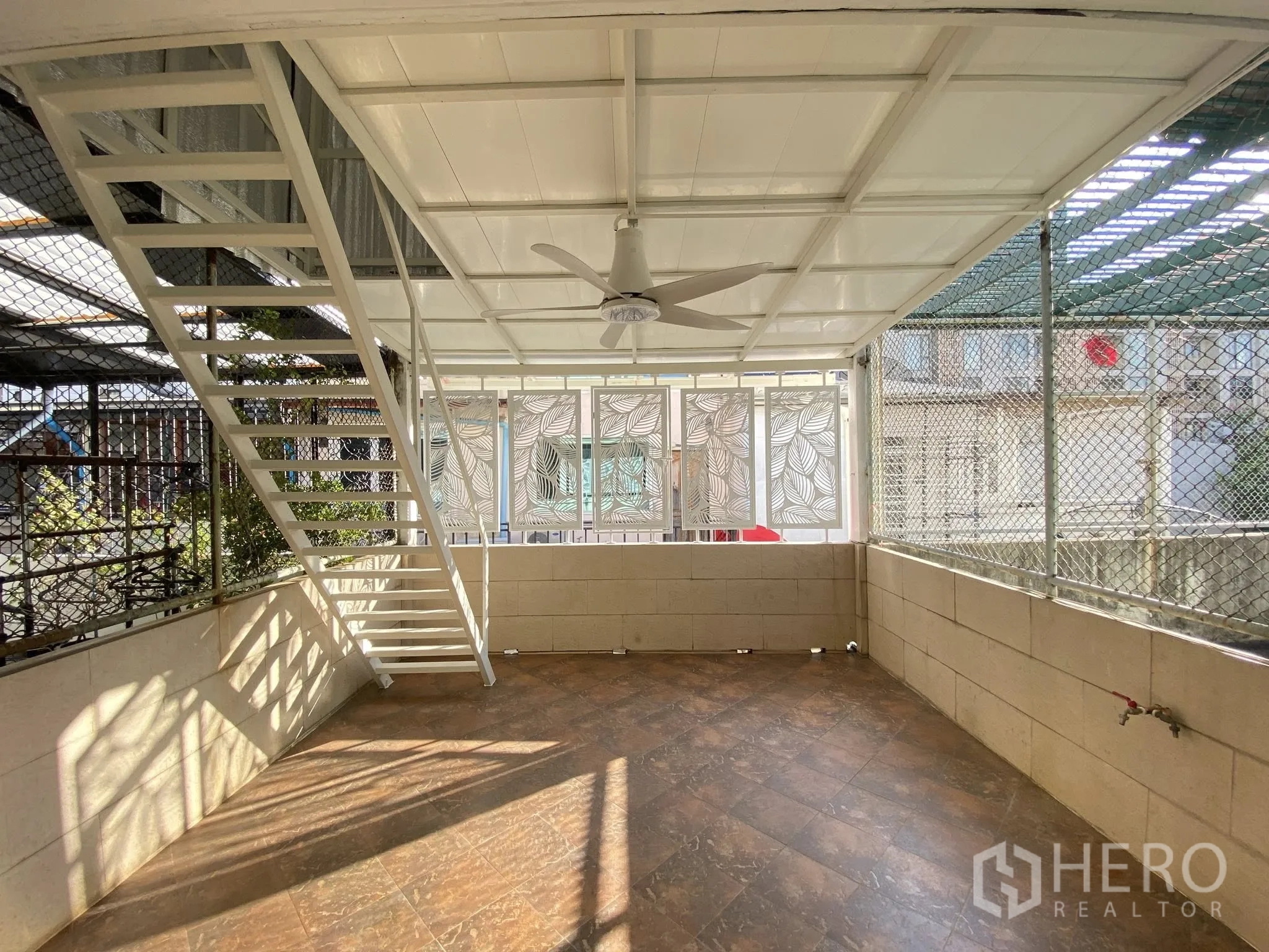 Home Office for rent in Pathum Wan, Bangkok - Covered terrace with ceiling fan, tiled floor, mesh screens, and stair to upper level.