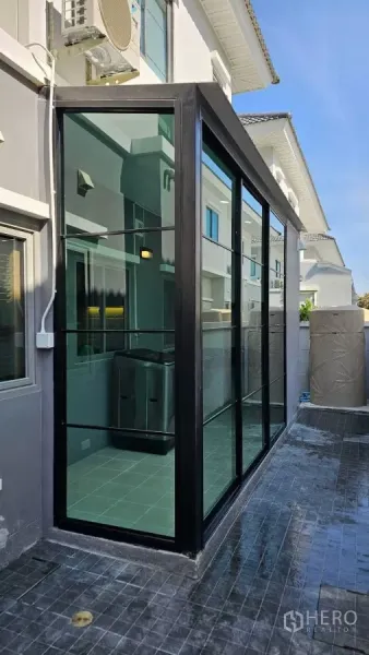 Detached House for rent in Bang Phli, Samut Prakan - Glass-enclosed side extension with sliding panels along the house exterior.