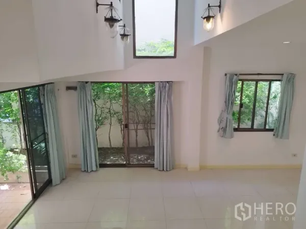 บ้าน ให้เช่าในWatthana, Bangkok - โถงรับแขกเพดานสูงสองชั้น หน้าต่างสูง ประตูกระจกสไลด์ติดสวน