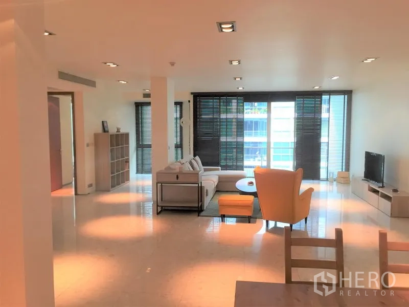 คอนโด ให้เช่าในKhlong Toei, Bangkok - ห้องนั่งเล่นสว่าง โปร่งด้วยหน้าต่างสูงจรดเพดาน ม่านบังแสง และชั้นวางทีวี