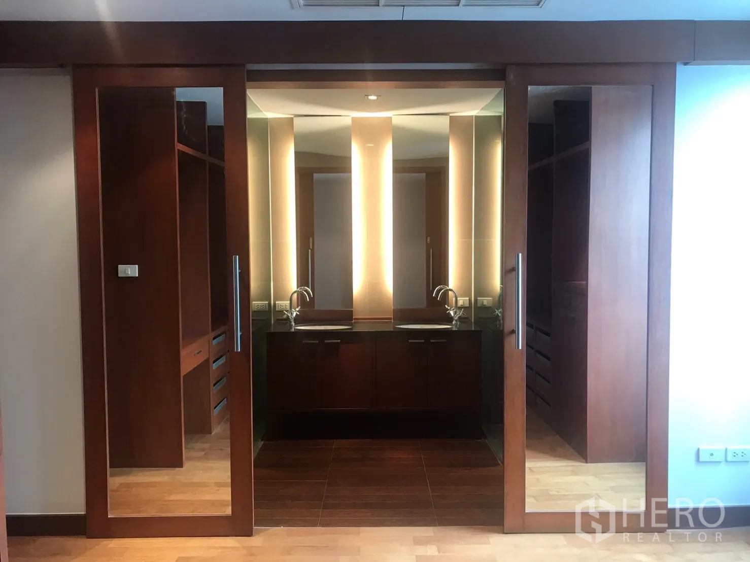 带办公室的家 出租在Watthana, Bangkok - 带镜面推拉门的更衣区，双洗手台与暖色木质橱柜。