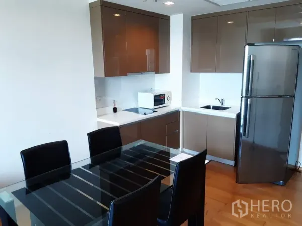 คอนโด ให้เช่าในKhlong Toei, Bangkok - ครัวมุมสไตล์โมเดิร์น ตู้ลอยเงา โต๊ะทานอาหารกระจก และตู้เย็นสแตนเลส