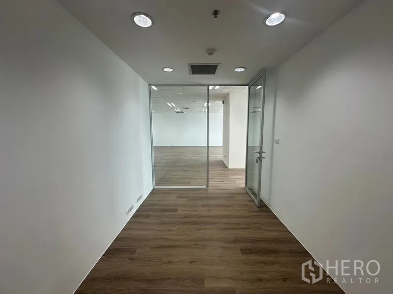สำนักงาน ให้เช่า - ห้องผู้บริหารทรงยาว มีดาวน์ไลท์ ประตูกระจกสู่พื้นที่หลัก และพื้นลายไม้.