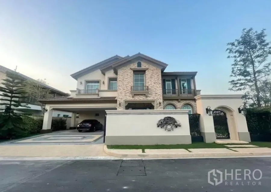 Detached House for rent in Bang Khen, Bangkok - Front elevation of elegant two-storey detached home with driveway and gate.
