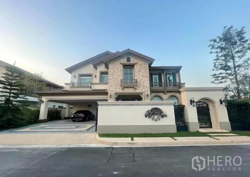 Detached House for rent in Bang Khen, Bangkok - Front elevation of elegant two-storey detached home with driveway and gate.