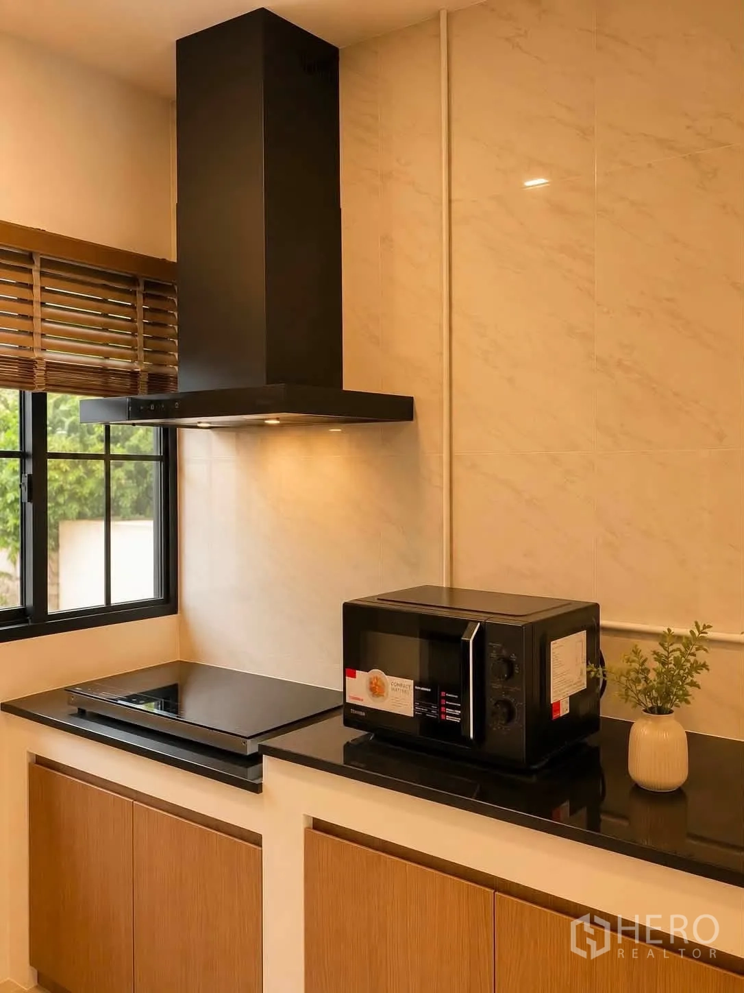 独栋房屋 for rent in Bang Phli, Samut Prakan - 现代厨房，黑色台面、窗户、灶台、油烟机与微波炉。