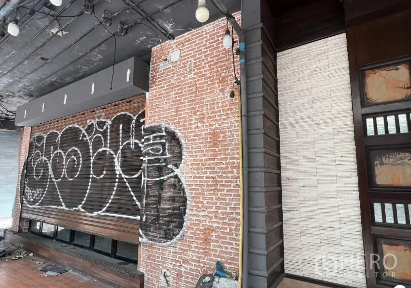 อาคารพาณิชย์ ให้เช่าในKhlong Toei, Bangkok - ระยะใกล้ผนังอิฐภายนอกกับประตูม้วนและโคมไฟใต้ฝ้า หน้าร้าน