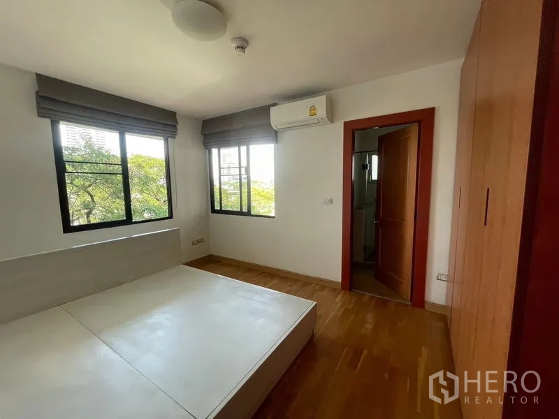 Condominium for rent in Watthana, Bangkok - Corner bedroom with built-in wardrobe, large windows and ensuite access.