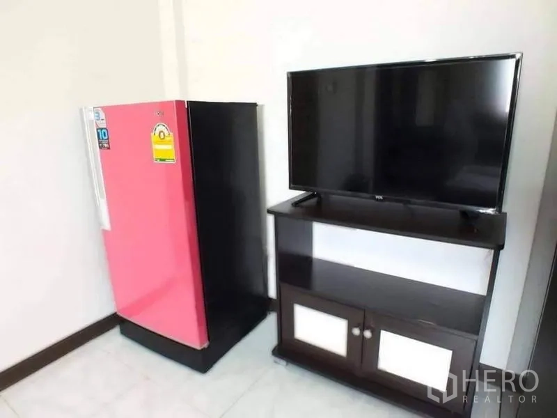 Shophouse for sale in Lam Luk Ka, Pathum Thani - Corner with pink refrigerator next to TV on stand.