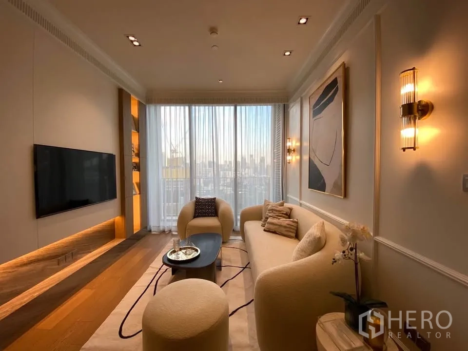 Condominium for rent in Pathum Wan, Bangkok - Full living room view with TV wall, warm ambient lighting, large window drapes, and modern furniture.