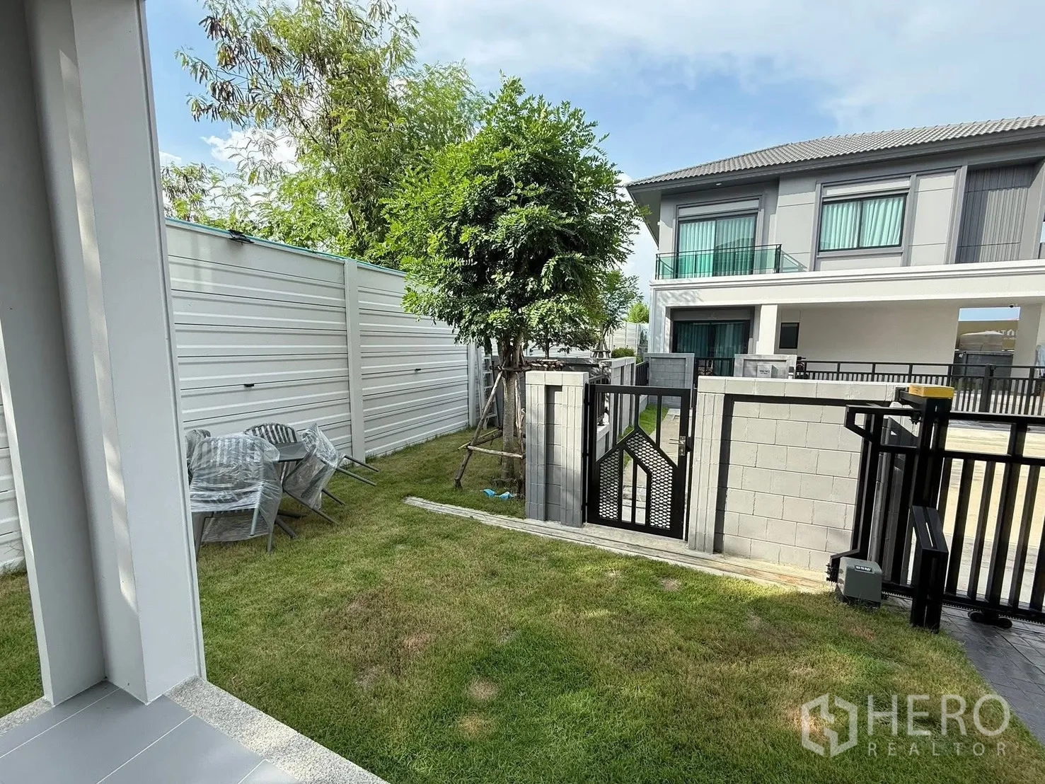 Detached House for rent in Bang Phli, Samut Prakan - Small garden and side gate opening to the driveway in a residential enclave.