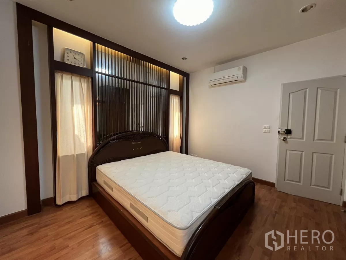 Detached House for rent in Bang Kapi, Bangkok - Master bedroom with feature headboard, warm lighting and curtains.