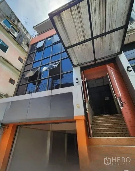 Office Space for rent or sale in Bueng Kum, Bangkok - Front elevation of the office building showing glass windows, metal awning and stair access.