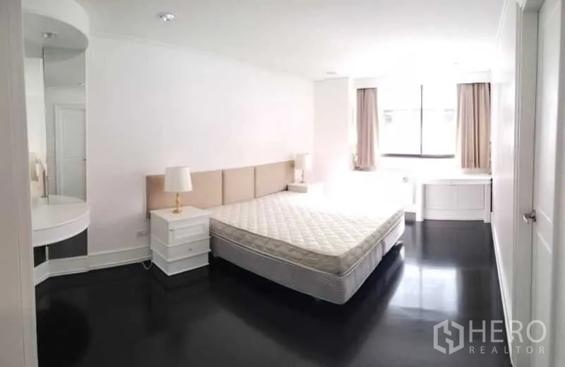 Condominium for rent in Sathon, Bangkok - Sunlit master bedroom with king bed, side tables and built-in vanity.