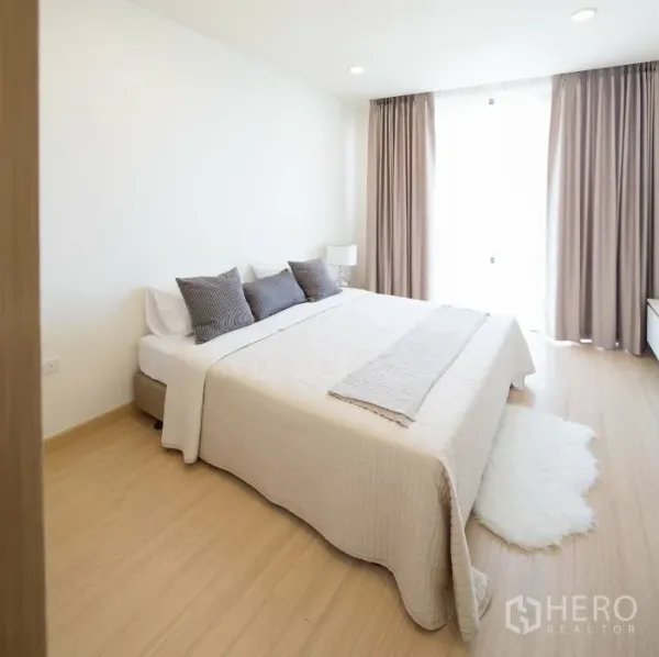 公寓 出租在Watthana, Bangkok - 第二卧室带大窗、米色窗帘与地毯，木质地板温暖舒适。