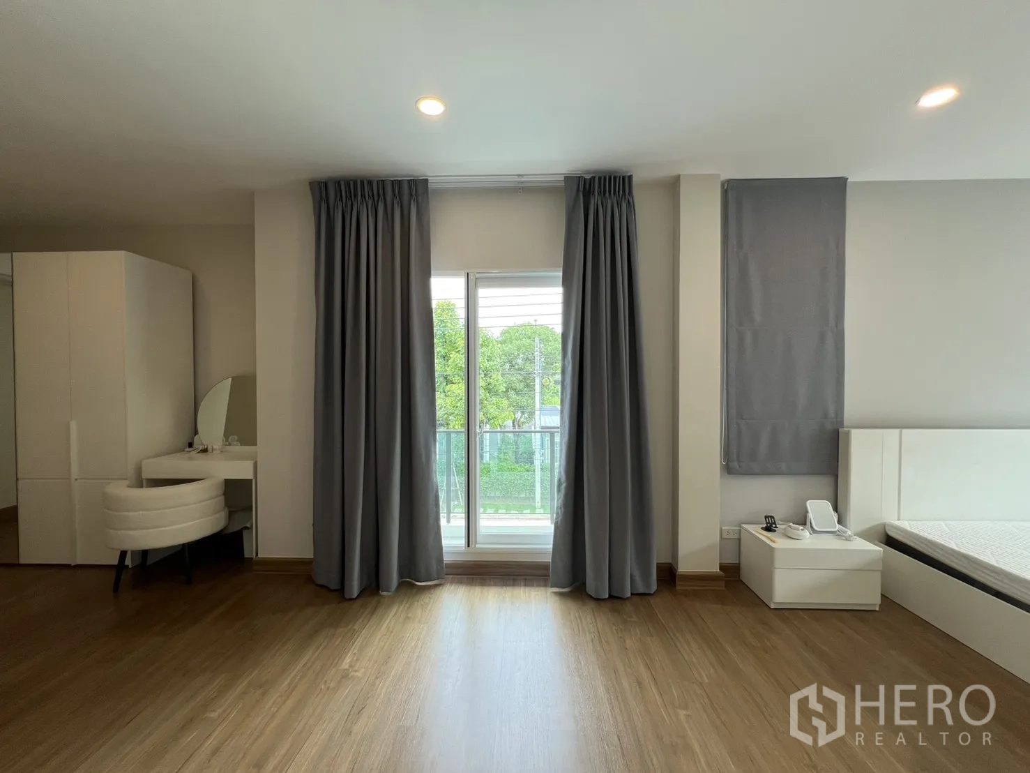Detached House for rent in Lat Krabang, Bangkok - Master bedroom with sliding doors to a balcony, vanity, and wardrobe.