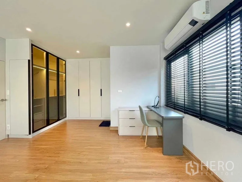 Detached House for rent in Bang Phli, Samut Prakan - Spacious bedroom or study with desk, built-in wardrobes, air conditioner and black blinds.