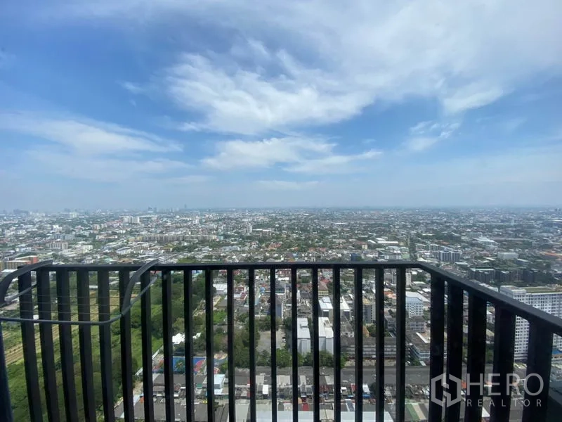 Condominium for rent in Phra Khanong, Bangkok - High-floor balcony with black railing overlooking a wide Bangkok city skyline under blue skies.