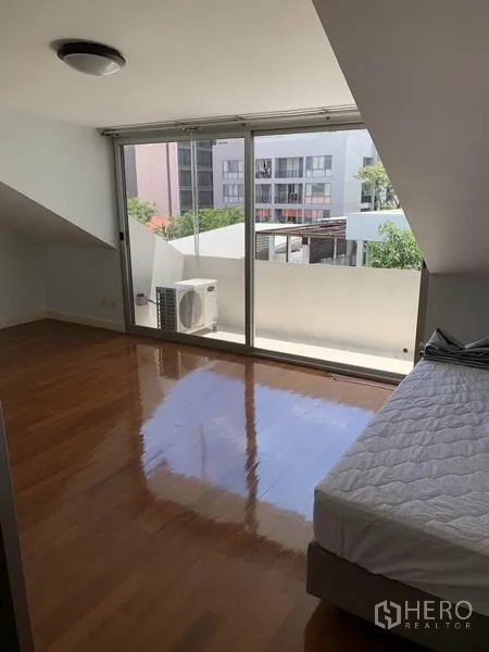 ทาวน์เฮาส์ ให้เช่าในKhlong Toei, Bangkok - ห้องนอนพื้นไม้เงา ประตูกระจกบานเลื่อนเต็มผนังเปิดสู่ระเบียงเล็ก