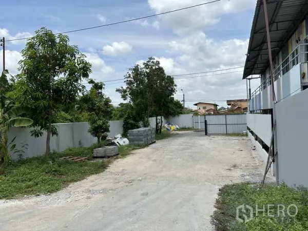 货栈 出租在Lat Krabang, Bangkok - 带大门的出入口道路，场地周围有围墙与树木，适合工业用途。