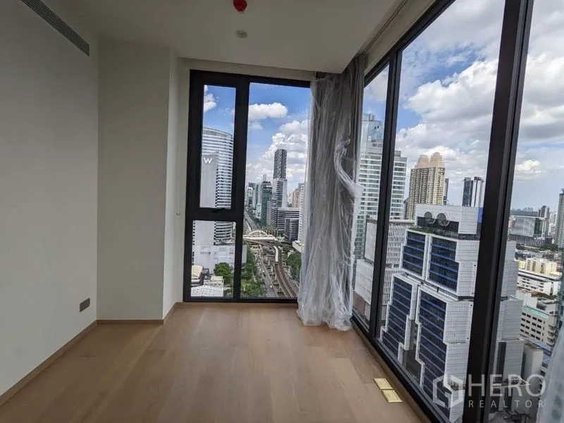 Condominium for sale - Corner bedroom with full-height glass walls offering panoramic city and BTS line views.
