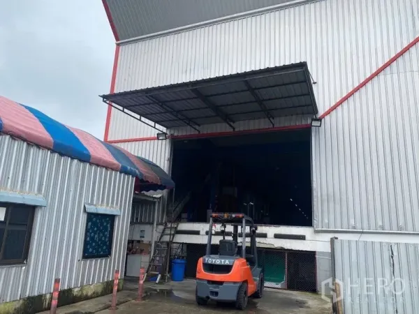 Factory for rent or sale in Lam Luk Ka, Pathum Thani - Covered loading dock at the warehouse entrance with forklift access.