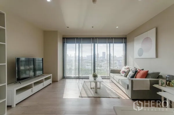 คอนโด ให้เช่าในWatthana, Bangkok - ตู้วางทีวีและชั้นโชว์ในห้องนั่งเล่นโทนเรียบ พื้นไม้