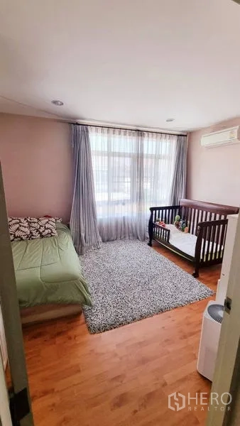 Detached House for rent or sale in Saphan Sung, Bangkok - Family bedroom with single bed, crib and area rug.