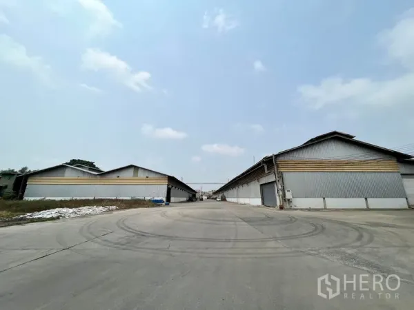 Warehouse for rent in Phra Samut Chedi, Samut Prakan - Broad access road between multiple warehouse blocks allowing trailer circulation.