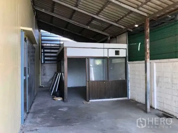 Factory for rent in Khlong Luang, Pathum Thani - Covered side utility area with a small outbuilding under a lean-to roof beside the main warehouse.