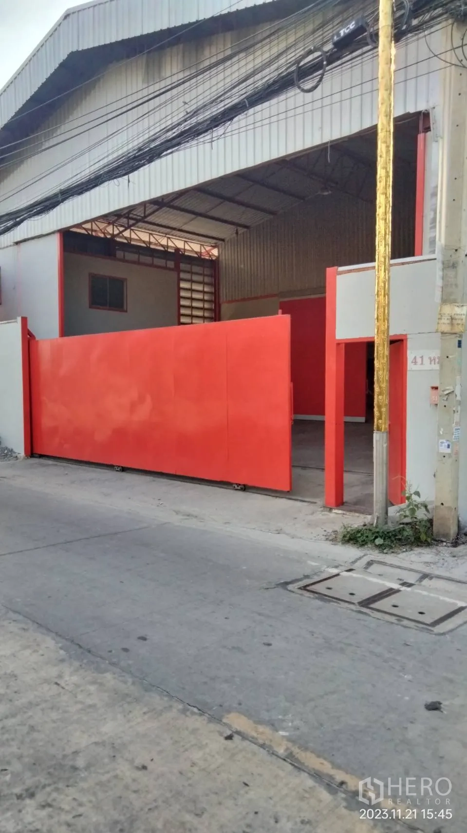 โกดัง for rent in Bang Phli, Samut Prakan - มุมมองจากถนนเห็นทางเข้าโกดังพร้อมประตูเหล็กบานเลื่อนขนาดใหญ่.