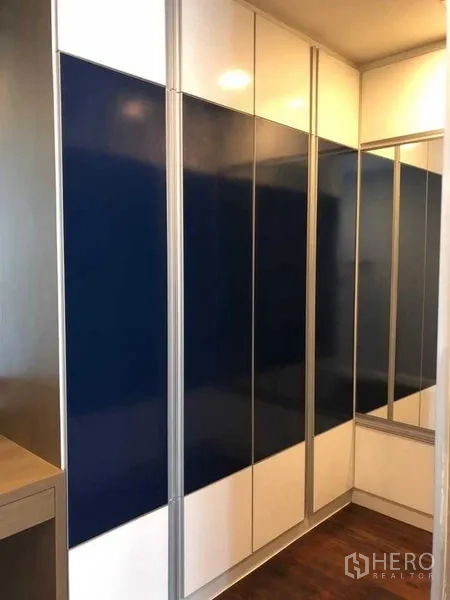 คอนโด ให้เช่าในKhlong Luang, Pathum Thani - ตู้เสื้อผ้าบิวท์อินบานเงาสีน้ำเงิน‑ขาวในห้องนอน