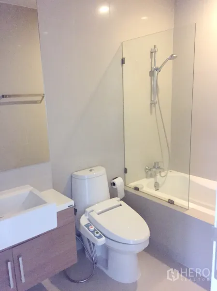 คอนโด ให้เช่าในBangkok - ห้องน้ำสมัยใหม่พร้อมอ่างล้างหน้า โถสุขภัณฑ์บิเดต์ อ่างอาบน้ำ และฉากกั้นอาบน้ำกระจก