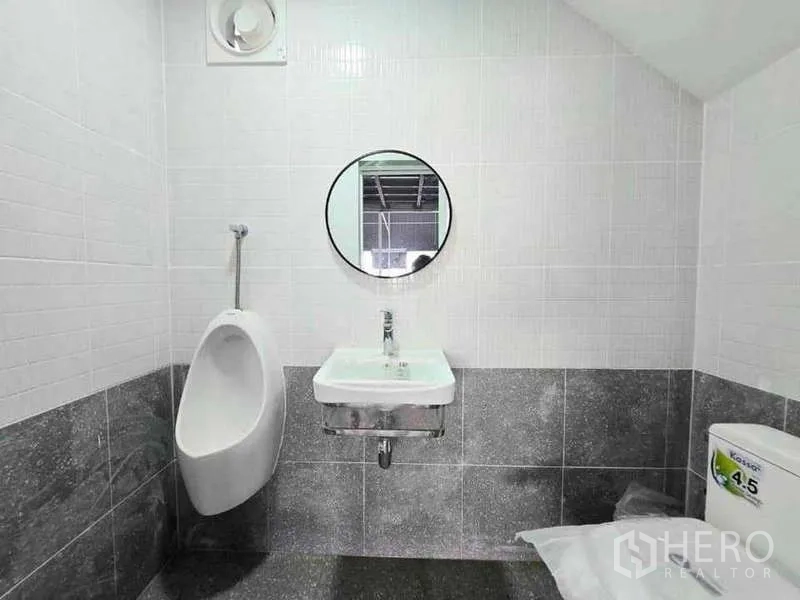 货栈 出租在Prawet, Bangkok - 整洁的瓷砖卫生间，配小便器、洗手盆、圆镜和坐便器