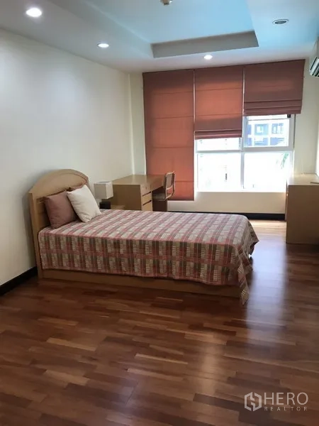 Condominium for rent in Watthana, Bangkok - Bright second bedroom with single bed, study desk, wood flooring and window blinds.