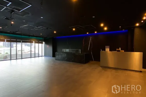 零售空间 出租 - 开放零售楼层，整面玻璃与前台接待柜台。