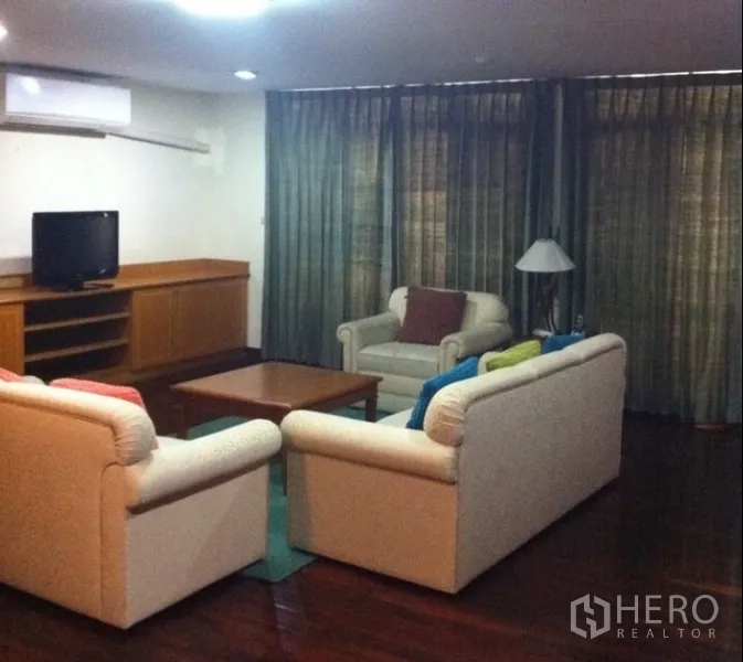 Condominium for rent in Watthana, Bangkok - Corner lounge with two sofas, a coffee table, and full-length curtains.