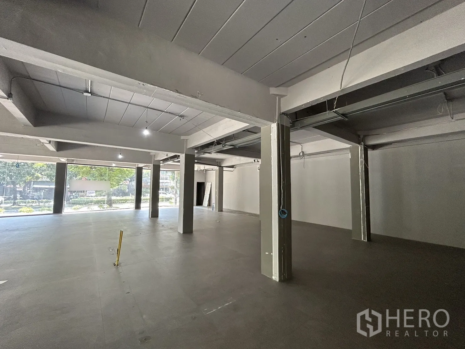 零售空间 出租在Suan Luang, Bangkok - 开间零售区，结构柱与裸露管线，灰色地面平整。