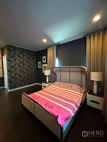 独立式住宅 出租在Bang Kapi, Bangkok - 卧室带特色墙纸、双人床、床头灯与遮光窗帘。