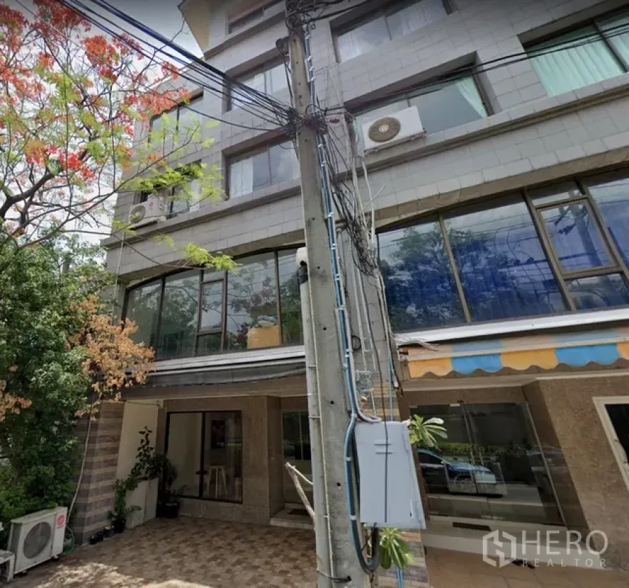 สำนักงานที่บ้าน ให้เช่าในWatthana, Bangkok - ด้านหน้าอาคารโฮมออฟฟิศหลายชั้น กระจกบานใหญ่ ลานกระเบื้อง และต้นไม้ร่มรื่น