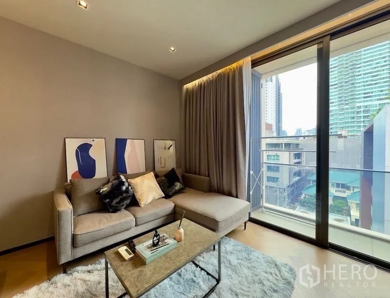 公寓 for rent or sale in Watthana, Bangkok - 明亮客厅配沙发与地毯，落地滑门通往阳台，享城市景观。