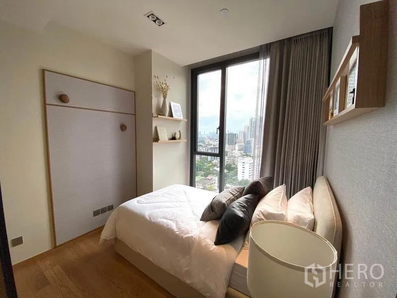 Condominium for rent or sale in Khlong Toei, Bangkok - Cozy second bedroom with large window, shelving and daytime city view.