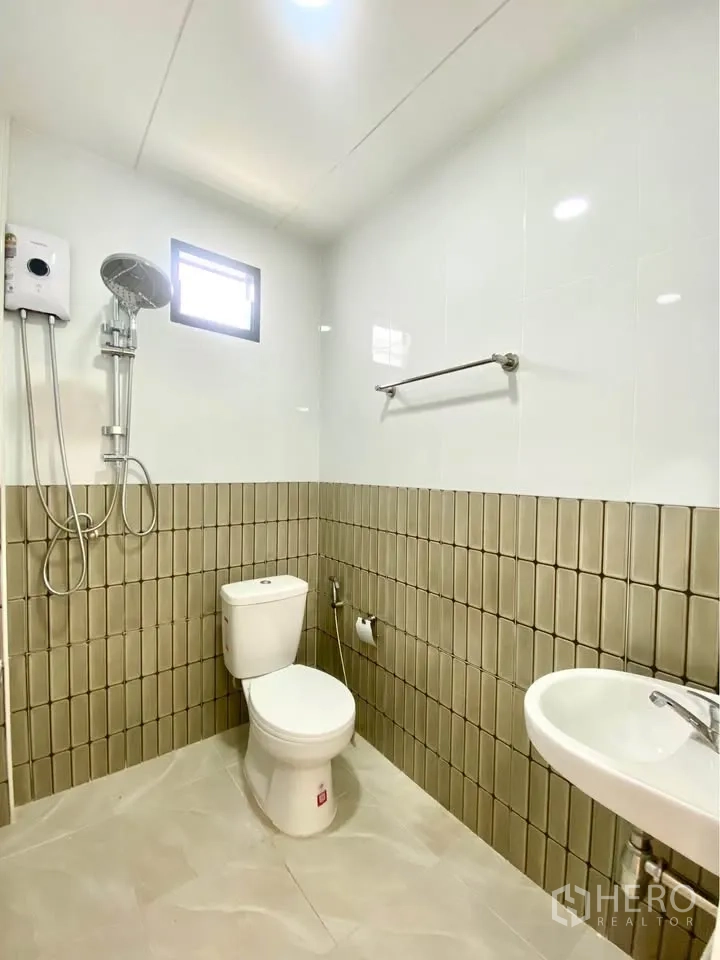 独栋房屋 for rent in Huai Khwang, Bangkok - 浴室铺砖，带淋浴与热水器、马桶、洗手盆与小窗。