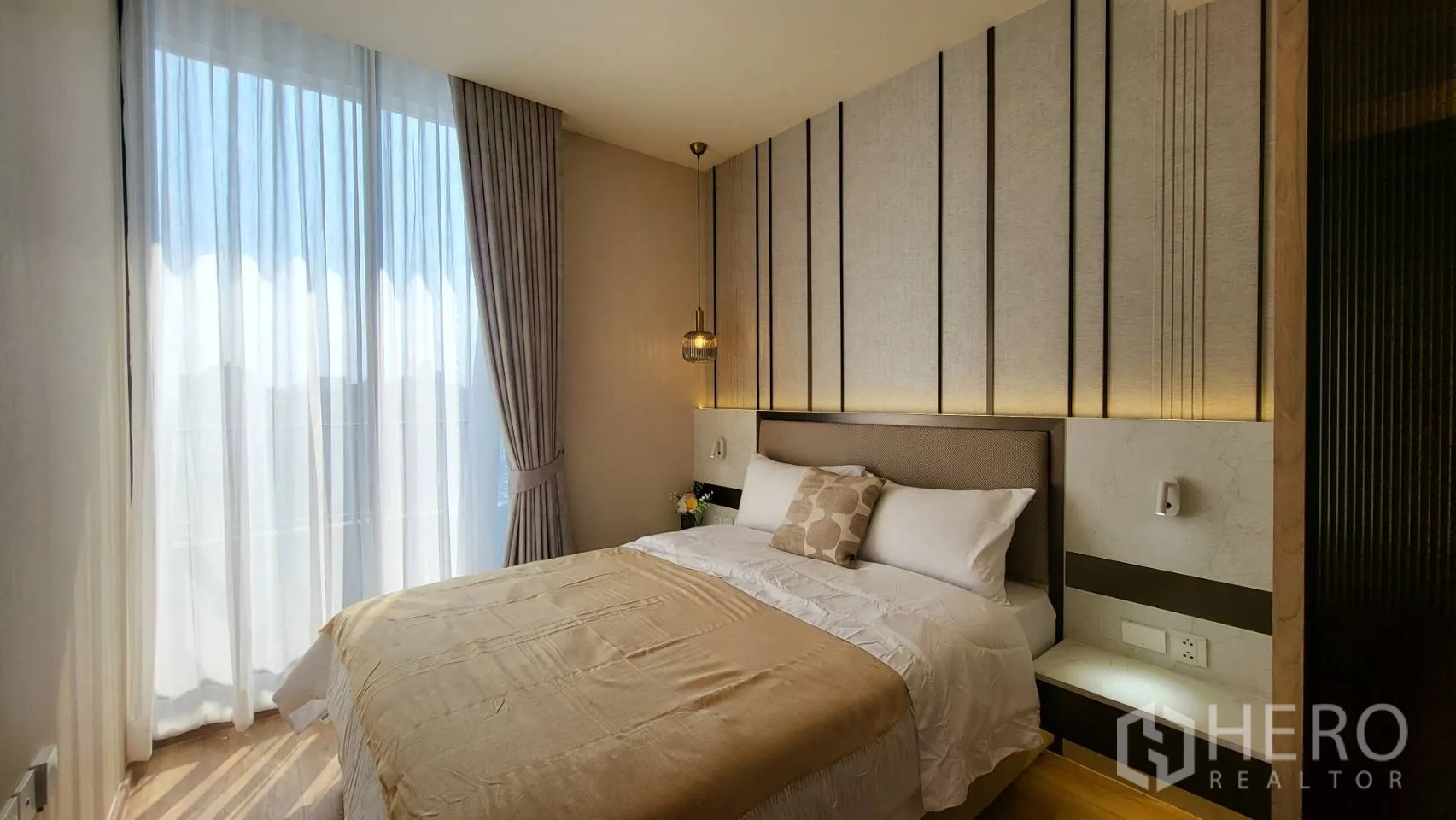 公寓 for sale in Watthana, Bangkok - 次卧设装饰墙、吊灯、大落地窗与柔软床品。